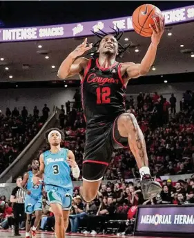  ?? Brett Coomer/Staff photograph­er ?? UH guard Tramon Mark sprints past Tulane guard Jalen Cook to the basket during the second half. The Cougars won their eighth straight game.