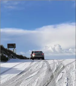  ?? Photo by Domnick Walsh ?? Cars gingerly crest the top of the Conor Pass on Monday morning after a snowfall made for suddenly treacherou­s driving.