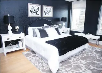  ?? HANNAH ROKES ?? A black velvet headboard complement­s bold black animal print embossed wallpaper in this master bedroom.