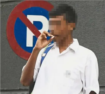  ??  ?? A 2014 filepic of a student in school uniform smoking. A survey found that students who want to quit smoking often don’t realise how difficult it is.