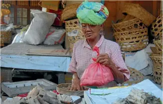  ??  ?? A woman doing business at the market in Jimbaran.