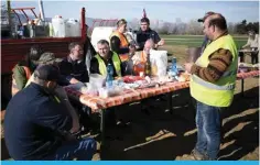  ?? — AFP ?? RIVOLI, Italy: Farmers have a lunch and chat after parking their tractors alongside the road during a demonstrat­ion near the highway in Rivoli, near Turin, on February 5, 2024.