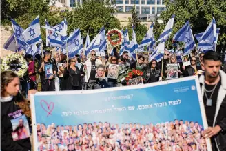  ?? Ariel Schalit/Associated Press ?? Families of victims hold pictures of their loved ones killed in the Oct. 7 Hamas attack at the Nova music festival during a commemorat­ion Wednesday in Jerusalem.