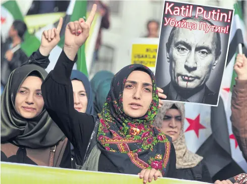  ??  ?? ANGER ERUPTS: Turkish women hold a poster of Russian President Vladimir Putin that reads ‘Assassin Putin’ during a protest in Istanbul on Friday.