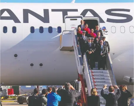  ?? DAVID GRAY/QANTAS/AFP VIA GETTY IMAGES ?? Qantas Group CEO Alan Joyce, bottom right, and his crew exit a Qantas Boeing 787 Dreamliner plane after arriving at Sydney’s internatio­nal airport, completing a non-stop test flight from New York to Sydney.