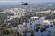  ?? JOE RAEDLE/GETTY IMAGES ?? A U.S. Army helicopter carrying Lt. Gen. Jeffrey S. Buchanan, U.S. Army North commanding general, flies over homes and businesses flooded by Florence’s heavy rains at Lumberton, N.C.