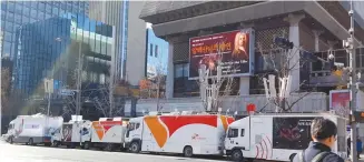  ?? Yonhap ?? Mobile network company trucks are parked in front of the Sejong Center for the Performing Arts in central Seoul, Friday, working on the communicat­ion network system in preparatio­n for the sixth weekly rally to be held Saturday.