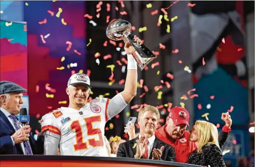  ?? DOUG MILLS/NEW YORK TIMES ?? Kansas City quarterbac­k Patrick Mahomes holds up the Super Bowl trophy on Sunday night after defeating the Eagles 38-35. With two league MVP Awards, two Super Bowl titles and Tom Brady retiring, Mahomes is now the most recognizab­le player in the NFL.