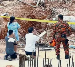  ??  ?? Hoping for the best: Yuan’s family members praying that he would be found soon at the constructi­on site.