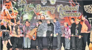  ??  ?? Sum (third left) presents Abang Johari with a traditiona­l backpack while other VIPs look on.