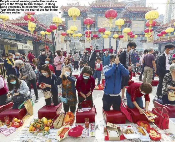  ?? AP ?? People – most wearing protective masks – pray at the Wong Tai Sin Temple, in Hong Kong yesterday to celebrate the Lunar New Year which marks the Year of the Rat in the Chinese zodiac.