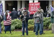  ?? TED S. WARREN — THE ASSOCIATED PRESS FILE ?? Two men stand armed with guns on Jan. 6, 2021, in front of the Governor’s Mansion in Olympia, Wash., during a protest supporting then-President Donald Trump and against the counting of electoral votes in Washington, D.C., affirming then-President-elect Joe Biden’s win.