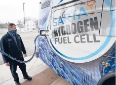  ?? TONY DEJAK/AP ?? Kevin Baker, a maintenanc­e technician, refuels a hydrogen fuel cell bus in March in Canton, Ohio. Hydrogen power may be the key to reduce carbon emissions.