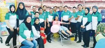  ??  ?? SABARUDIN (sebelah kiri salah seorang penderma) merakamkan album bersama pegawai dan anggota SJAM.