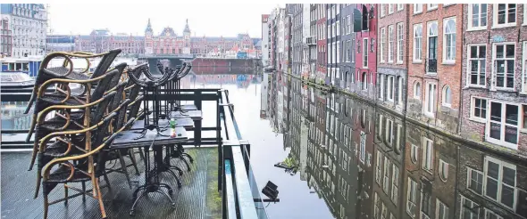  ?? FOTO: PAULO AMORIM/IMAGO IMAGES ?? Am Damrak-Kanal in Amsterdam bleiben die Restaurant­s geschlosse­n. Die Niederland­e sind im Lockdown, doch geimpft wird noch nicht.