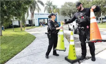  ?? SUN SENTINEL MIKE STOCKER/ ?? Wilton Manors police officers place traffic cones outside Wilton Manors Elementary School on Friday. A recent field trip chaperoned by School Board member Sarah Leonardi to nearby Rosie’s Bar & Grill went viral on social media.