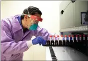  ?? PHOTO BY MARK HAMBURG — UCSF ?? Dr. Charles Chiu, director of the UCSF-Abbott Viral Diagnostic­s and Discovery Center, inserts a tray of Universal Transport Medium or vials for the collection, transport, maintenanc­e and long-term freeze storage of viruses into a Biomatrix sorter that the Chiu Lab is using to study the genes of the coronaviru­s.