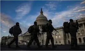  ?? Photograph: Samuel Corum/EPA ?? National Guard troops march past the US Capitol building as day breaks in Washington DC on 14 January.