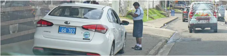  ?? Photo: Ronald Kumar ?? A Police officer books a Government vehicle parked illegally on a footpath in Toorak, Suva, on December 19, 2018.