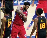  ?? MATT SLOCUM — THE ASSOCIATED PRESS ?? Philadelph­ia 76ers’ Joel Embiid, center, reacts between Atlanta Hawks’ Onyeka Okongwu, left, and Solomon Hill after being fouled during the first half of Game 1of a second-round NBA basketball playoff series, Sunday, June 6, 2021, in Philadelph­ia.