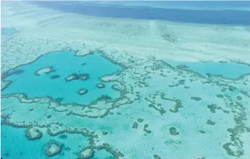  ??  ?? File photo shows an aerial view of the Great Barrier Reef off the coast of the Whitsunday Islands, along the central coast of Queensland. Among the 241 natural sites classified as World Heritage by Unesco, 62 are now ‘threatened by climate change’...