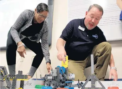  ?? LESLIE OVALLE/STAFF PHOTOGRAPH­ER ?? Marcia Martin, left, a teacher, and Kelly W. Ryan, right, the reset the obstacle course for "Battle of the Bots.” director of regional operations for the Robotics Education and Competitio­n Foundation,