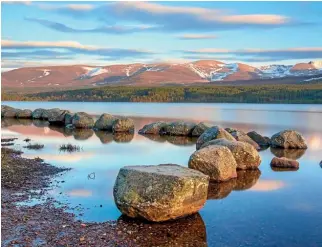  ?? ISTOCK ISTOCK ?? Loch Morlich in the Cairngorm National Park, Scotland. Stunning summer alpine landscape with green fields and high snowy mountains in Bran, Transylvan­ia, Romania.