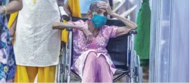  ?? Associated Press ?? ↑
An elderly woman waits to receive vaccine at a vaccinatio­n centre in Mumbai on Sunday.