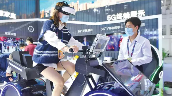  ?? ?? A visitor tries a VR spinning based on 5G technology at the digital achievemen­ts exhibition during the fourth Digital China Summit in Fuzhou, southeast China’s Fujian Province, April 25, 2021. Photo: Xinhua