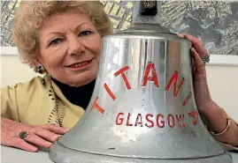  ??  ?? Anne Erwin, in 2004, with the bell her father saved from the Titania when it sank. The bell is now used at Wellington Central City Fire Station.