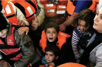  ?? ARIS MESSINIS/AFP/GETTY IMAGES ?? Syrian refugees are rescued by Greek fishermen as their boat sinks off the Greek island of Lesbos.