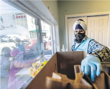  ?? DARREN STONE, TIMES COLONIST ?? Volunteer Bhavin Singh hands out food provided by the Victoria chapter of Khalsa Aid Canada to people in need at the Mustard Seed Street Church on Tuesday. It’s all part of the society’s pandemic-focused outreach, with an extra effort made to mark Vaisakhi.