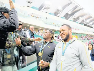  ?? AP ?? Jamaica’s Fedrick Dacres is greeted by coaches and fans after receiving his gold medal for the men’s discus throw competitio­n during the Pan American Games in Lima, Peru, Tuesday, August 6, 2019. At right is friend and silver medallist Traves Smikle, also of Jamaica.