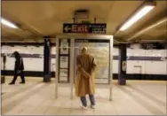  ?? JULIE JACOBSON — THE ASSOCIATED PRESS FILE ?? In this file photo, a passenger waiting for a Brooklyln bound A train reads the subway line map at the 42nd Street station in New York. If you’re a transporta­tion buff, New York City is the perfect destinatio­n.