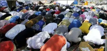  ?? AARON FAVILA - THE ASSOCIATED PRESS ?? Evacuees pray near tents outside a damaged mosque caused by the massive earthquake and tsunami in Palu, Central Sulawesi, Indonesia Friday.