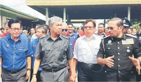  ??  ?? Zahid (second left) and Abang Johari (second right) listening to a briefing by Mustafar (right) at the Tebedu ICQS complex yesterday. At left is Lee.