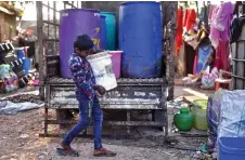  ?? ?? A boy unloading cans of water collected from the restored Bingipura lake in Bengaluru.