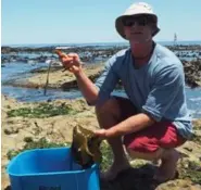  ?? NADIA EL FERDAOUSSI ?? Cape Town food forager Charles Standing shows off his spoils on one of the city’s beaches.