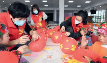  ??  ?? Volunteers make lanterns with migrant workers’ children in Huzhou, Zhejiang Province in east China, on January 21