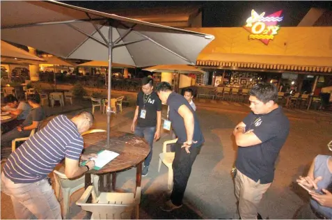  ?? JOY TORREJOS ?? A representa­tive of MO2 resto bar receives the show cause order from Mandaue City officials last night.
