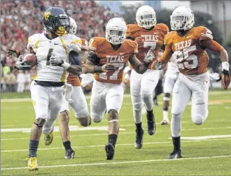  ??  ?? West Virginia wide receiver Tavon Austin, outrunning four Texas defenders to the end zone early this season, averaged a Big 12-best 230.6 all-purpose yards per game.