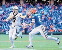  ?? SAM GREENWOOD/GETTY ?? Missouri quarterbac­k Drew Lock, left, pushes past UF’s Brad Stewart Jr. during the Tigers’ road win over the Gators.