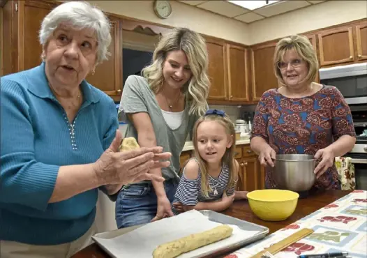  ?? Lake Fong/ Post- Gazette ?? Leona Cole, left, of Monongahel­a, makes cookie dough with her granddaugh­ter, Emily Giovannucc­i, second from left, great granddaugh­ter, Saige Giovannucc­i, and daughter Deborah Cole, at her home in Monongahel­a.