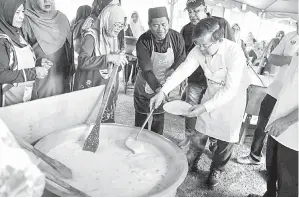  ?? — Gambar Bernama ?? BUBUR LAMBUK: Chow bersama penduduk setempat memasak bubur lambuk pada Program Bubur Lambuk bersama Ketua Menteri Pulau Pinang di Masjid Jamiul Sharif Pokok Machang di Tasek Gelugor semalam.