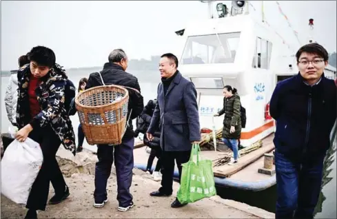  ?? AFP ?? Passengers get off Yang Zeqiang’s boat as it arrives at the bank opposite Zhongba, a small island near to the southweste­rn city of Chongqing.