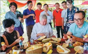  ?? PROVIDED TO CHINA DAILY ?? Chua Lam (center), a food critic from Hong Kong, joins visitors on a trip to a Malaysian durian farm.