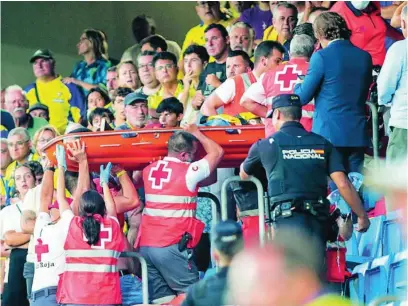  ?? EFE ?? El aficionado que sufrió un ataque al corazón es trasladado al hospital tras ser reanimado en el estadio