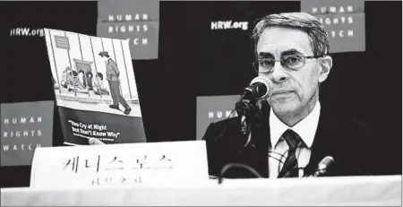 ?? ED JONES/GETTY-AFP ?? Human Rights Watch executive director Kenneth Roth holds a copy of a report into sexual abuse against women in North Korea.