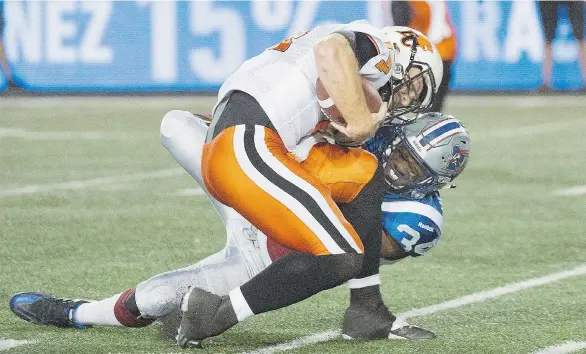  ?? GRAHAM HUGHES/ THE CANADIAN PRESS ?? Quarterbac­k Travis Lulay of the B.C. Lions is tackled by Montreal Alouettes’ Kyries Hebert during the first quarter of Thursday’s CFL game in Montreal. Lulay was injured on the play.