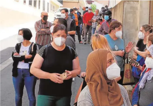  ??  ?? Trabajador­es agrarios haciendo cola, ayer, ante el centro de vacunación habilitado en Caspe (Zaragoza)